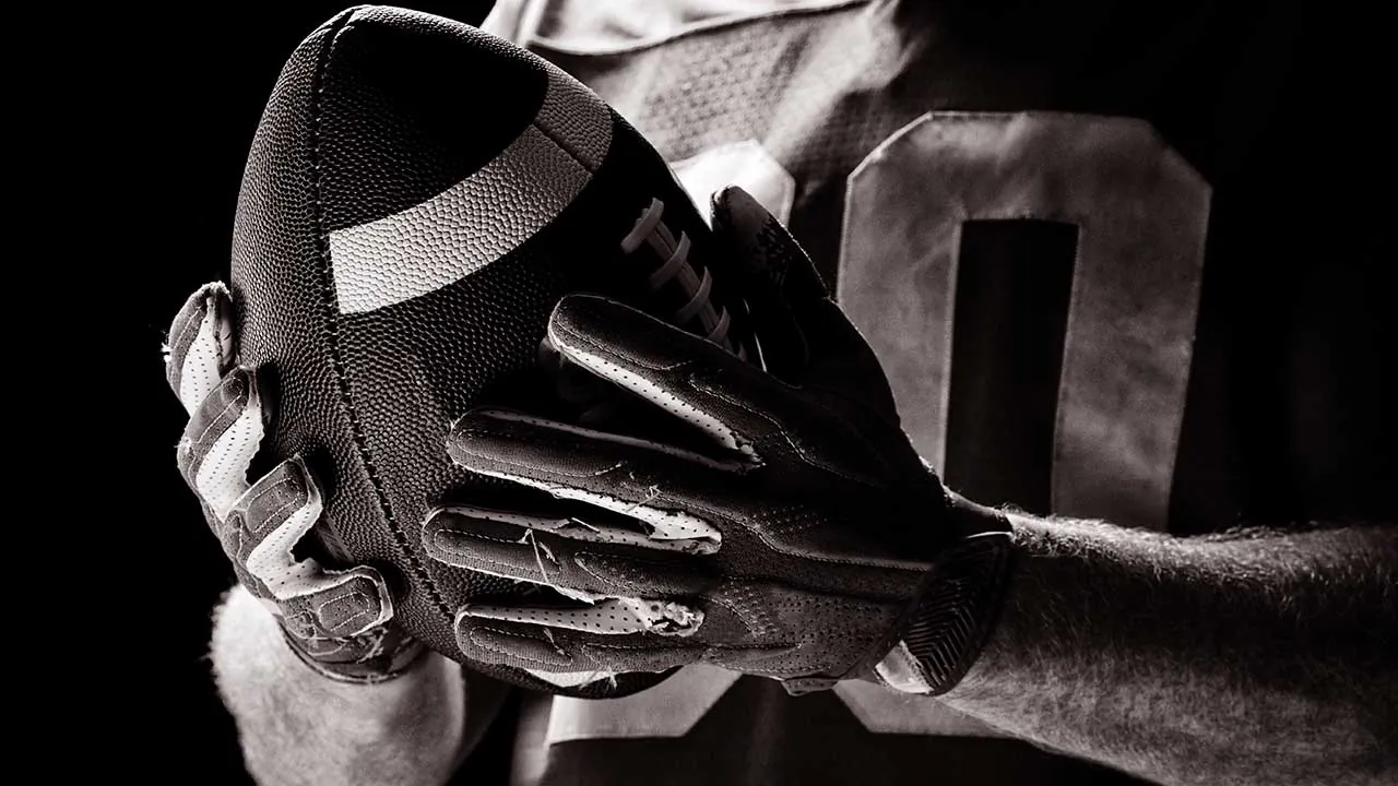 Football in gloved hands