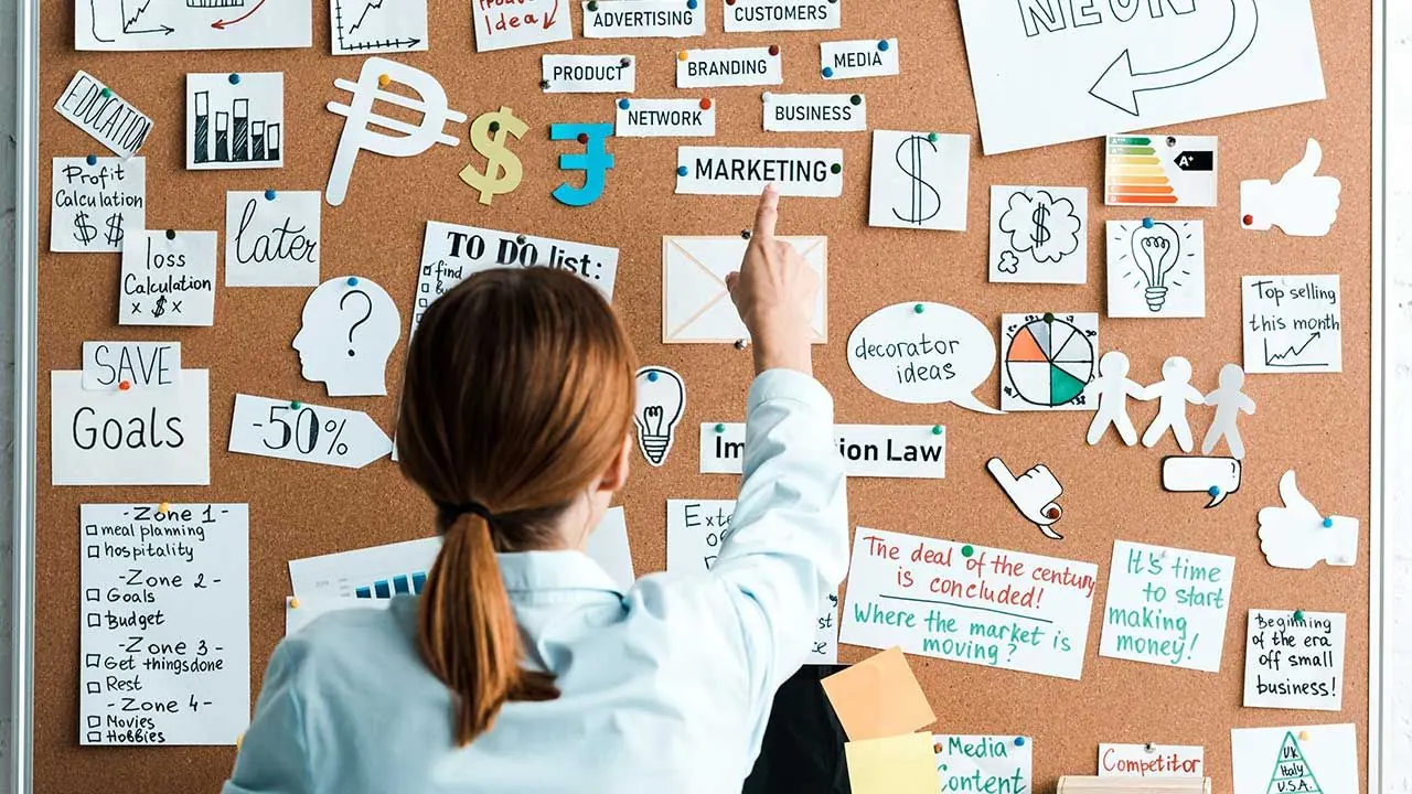 Marketer planning on corkboard